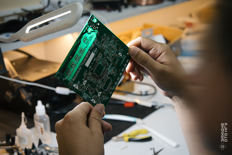 A Ukrainian workshop specialist inspecting an electronic circuit board; reference photograph from the National Guard of Ukraine